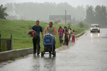 Scucyn  Weissrussland  Menschen auf der Strasse bei sehr starkem Regen