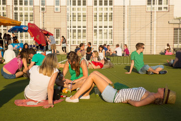 Berlin  Deutschland  Menschen entspannen in der Sonne auf einem Sportplatz
