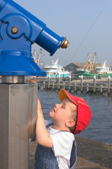 Oudeschild  Niederlande  kleiner Junge an einem Fernrohr im Hafen