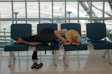Bangkok  Thailand  schlafende Frau im Abflugbereich auf dem Flughafen Bangkok
