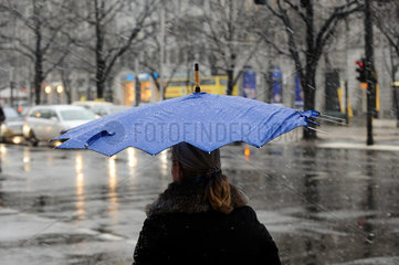 Berlin  Deutschland  Frau mit Regenschirm bei Schneeregen