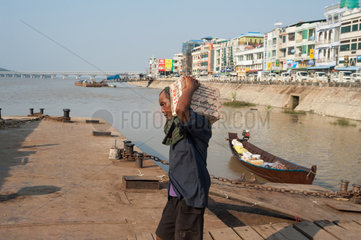 Mawlamyaing  Myanmar  Arbeiter belaedt ein Frachtschiff