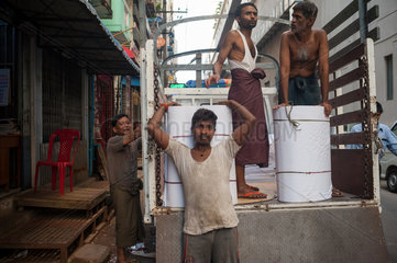 Yangon  Myanmar  Arbeiter entladen Lagen von Papier