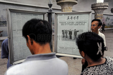 Pjoengjang  Nordkorea  wartende Fahrgaeste lesen am U-Bahnsteig Zeitung.
