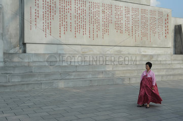 Pjoengjang  Nordkorea  eine Frau an der Inschrift des Chuche-Turms