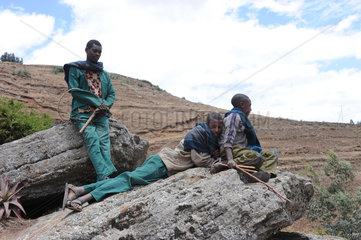 Mangudo  Aethiopien  jugendliche Hirten machen Pause auf einem Felsen