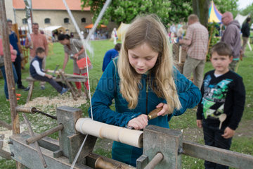 Schleswig  Deutschland  Maedchen probiert eine historische Drechselmaschine aus
