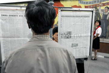 Pjoengjang  Nordkorea  wartende Fahrgaeste lesen am U-Bahnsteig Zeitung.