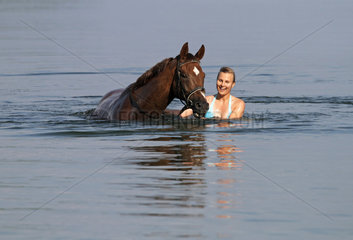 Schwerin  Deutschland  junge Frau badet mit ihrem Pferd im Schweriner See