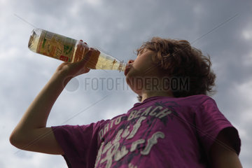 Zossen  Deutschland  Junge trinkt Biolimonade aus einer Flasche