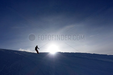 Kloesterle am Arlberg  Oesterreich  Silhouette  ein Mann faehrt Ski