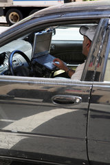New York City  USA  PKW-Fahrer mit Laptop im Auto