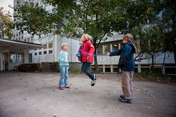 Berlin  Deutschland  Maedchen mit einem Springseil auf dem Schulhof