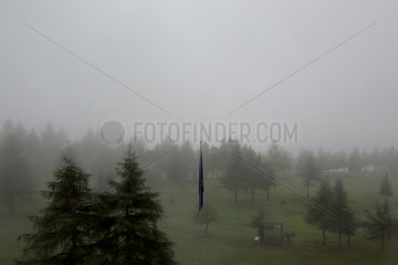 Riederalp  Schweiz  Blick ueber eine Golfanlage bei Nebel