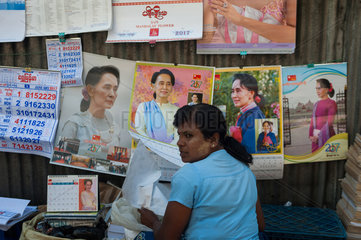 Yangon  Myanmar  Strassenhaendler verkauft Poster von Aung San Suu Kyi