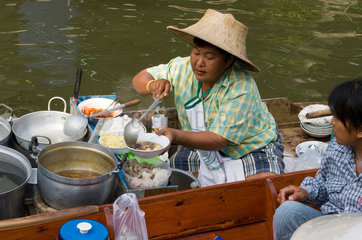 Damnoen Saduak  Thailand  eine Haendlerin verkauft Essen auf dem schwimmenden Markt