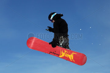 Kloesterle am Arlberg  Oesterreich  ein Junge faehrt Snowboard