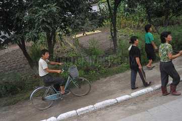 Wonsan  Nordkorea  Strassenszene mit Passanten und Radfahrer