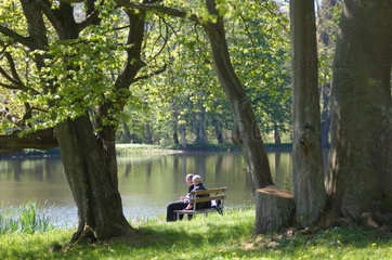 Putbus  Deutschland  Besucher sitzen am Schwanenteich im Schlosspark