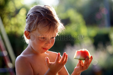 Berlin  Deutschland  Junge isst ein Stueck Wassermelone