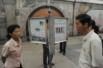 Pjoengjang  Nordkorea  wartende Fahrgaeste lesen am U-Bahnsteig Zeitung