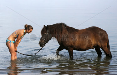 Schwerin  Deutschland  junge Frau steht mit ihrem Pony im Schweriner See