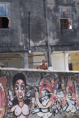 Brasilien  Junge guckt ueber eine Mauer