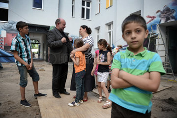 Berlin  Deutschland  Benjamin Marx im Gespraech mit einer Romafamilie im Hinterhof eines Wohnhauses in der Harzer Strasse in Berlin-Neukoelln