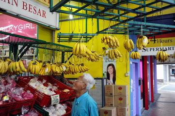 Singapur  Republik Singapur  Bananen haengen vor einem Lebensmittelgeschaeft