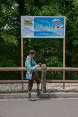 Hohenschwangau  Deutschland  ein Mann nutzt das kostenlose Wlan am Schloss Neuschwanstein