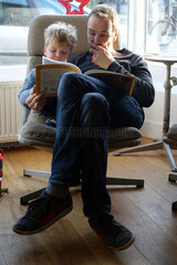 Utrecht  Niederlande  Vater schaut sich mit seinem Sohn ein Bilderbuch an