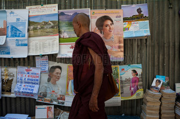Yangon  Myanmar  buddhistischer Moench bei einem Strassenhaendler