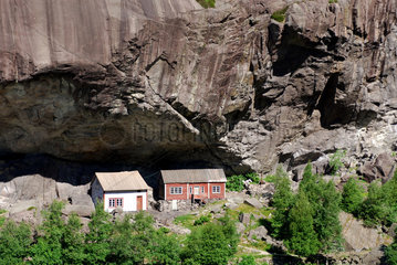 Helleren  Norwegen  alte Haeuser unter einem Felsvorsprung