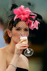 Iffezheim  Deutschland  Frau mit Hut trinkt ein Glas Champagner