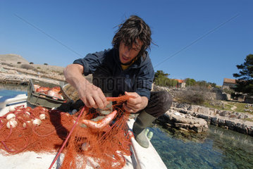 Sibenik  Kroatien  ein Fischer auf seinem Boot auf einer kleinen Insel vor Sibenik