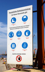 Emden  Deutschland  Schild mit Anweisungen zur persoenlichen Schutzausruestung / Arbeitssicherheit auf der Baustelle Nesserlander Schleuse