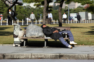 Tokio  Japan  Symbolfoto Armut  ein Mann schlaeft auf einer Parkbank