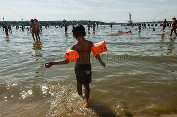 Berlin  Deutschland  Junge mit Schwimmfluegeln im Strandbad Wannsee