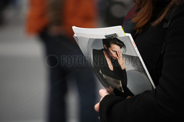 Berlin  Deutschland  wartende Frau am Bahnsteig mit einer Frauenzeitschrift