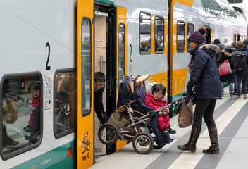 Berlin  Deutschland  Eltern heben einen Kinderwagen in einen Zug der ODEG