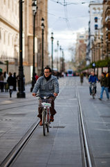 Sevilla  Spanien  ein Radfahrer faehrt zwischen den Strassenbahnschienen