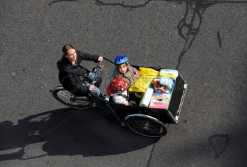 Berlin  Deutschland  Frau mit zwei Kindern auf einem Lastenrad