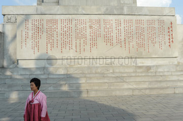 Pjoengjang  Nordkorea  eine Frau an der Inschrift des Chuche-Turms