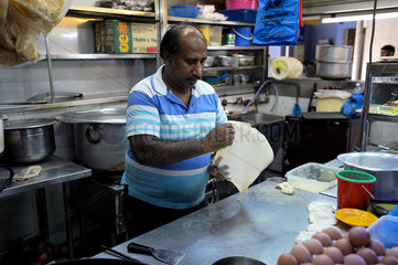 Singapur  Republik Singapur  ein Mann bereitet Roti Prata in einer Kueche vor