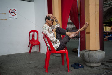 Singapur  Republik Singapur  ein Mann ruht sich auf einem Stuhl aus
