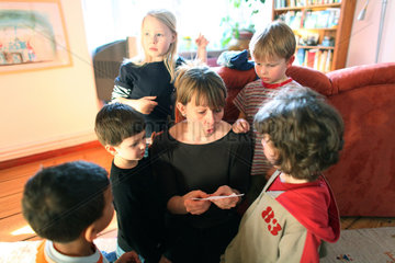 Berlin  Deutschland  Frau liest Kindern einen Brief vor