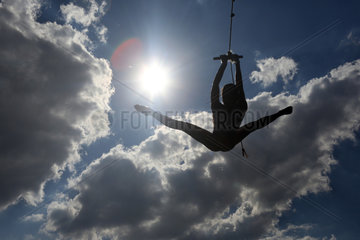 Briescht  Deutschland  Silhouette  Maedchen schwingt sich an einem Seil durch die Luft