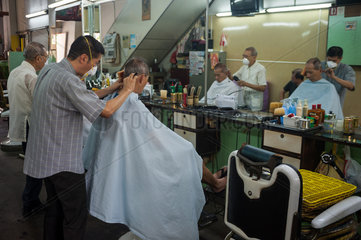 Singapur  Republik Singapur  Frisoer schneidet einem Kunden die Haare