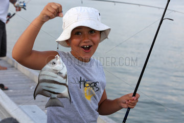 Pass a Grille Beach  USA  Junge zeigt stolz seinen geangelten Fisch