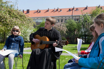 Krakau  Polen  Priester singt religioese Lieder mit einer Gruppe von Maedchen